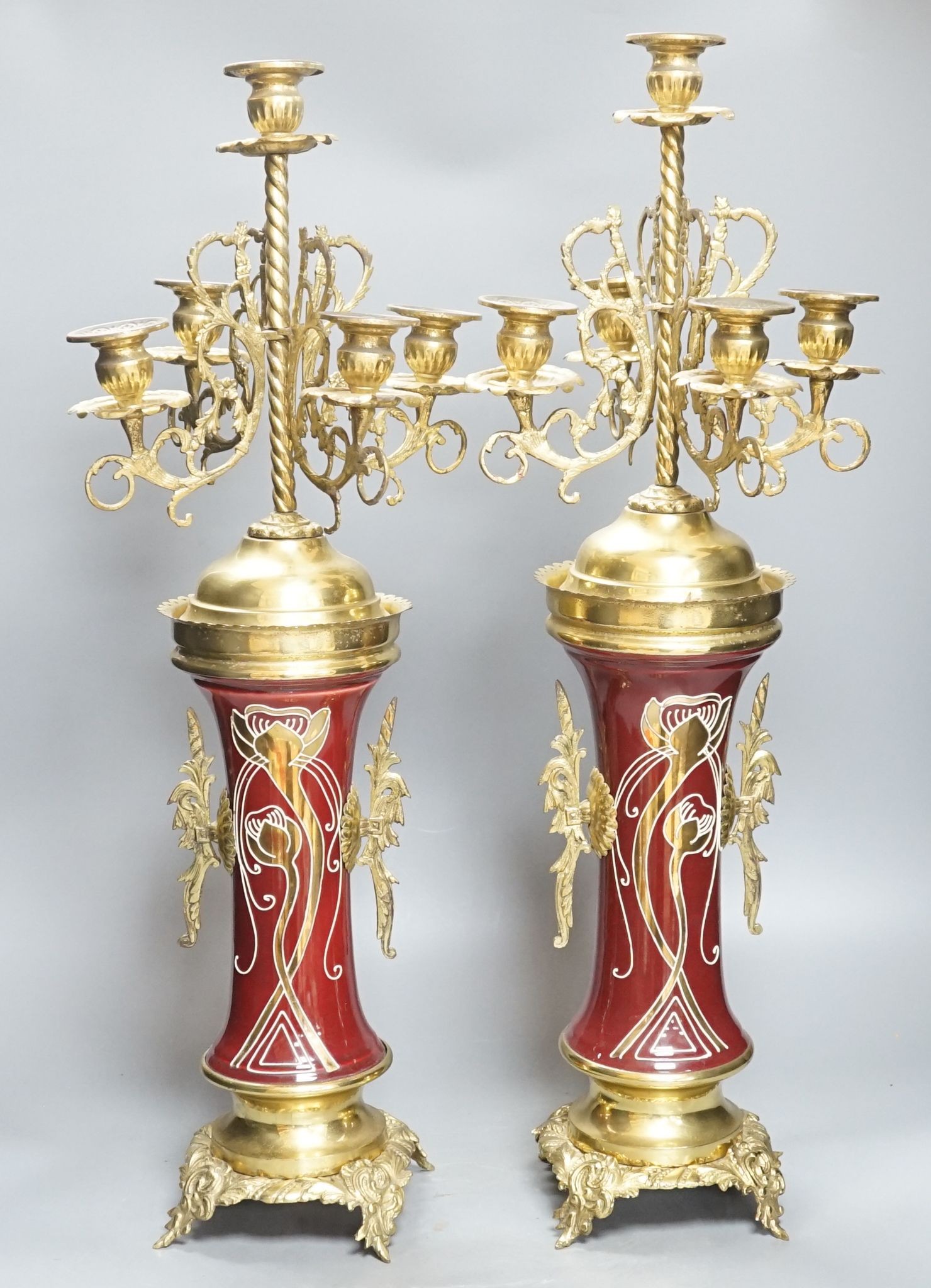 A pair of large brass and ceramic mounted candelabra, 64.5 cms high.